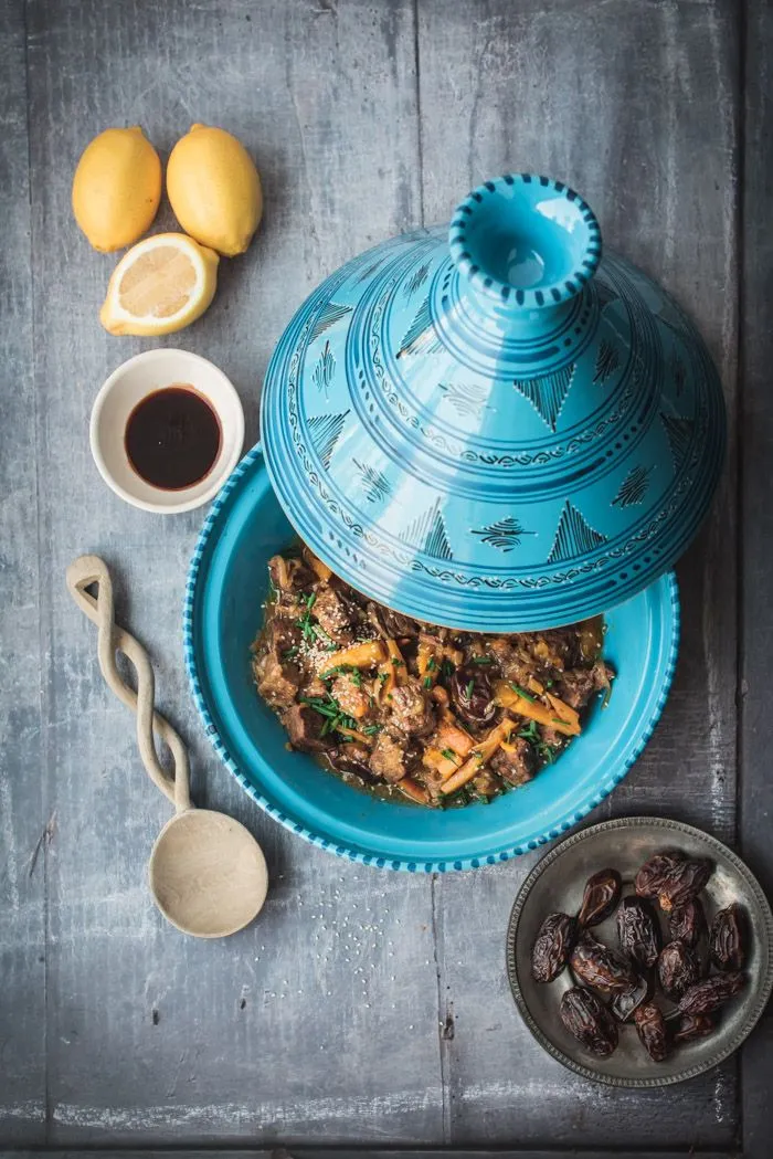 Blue ceramic tagine pot surrounded by colorful Moroccan spices